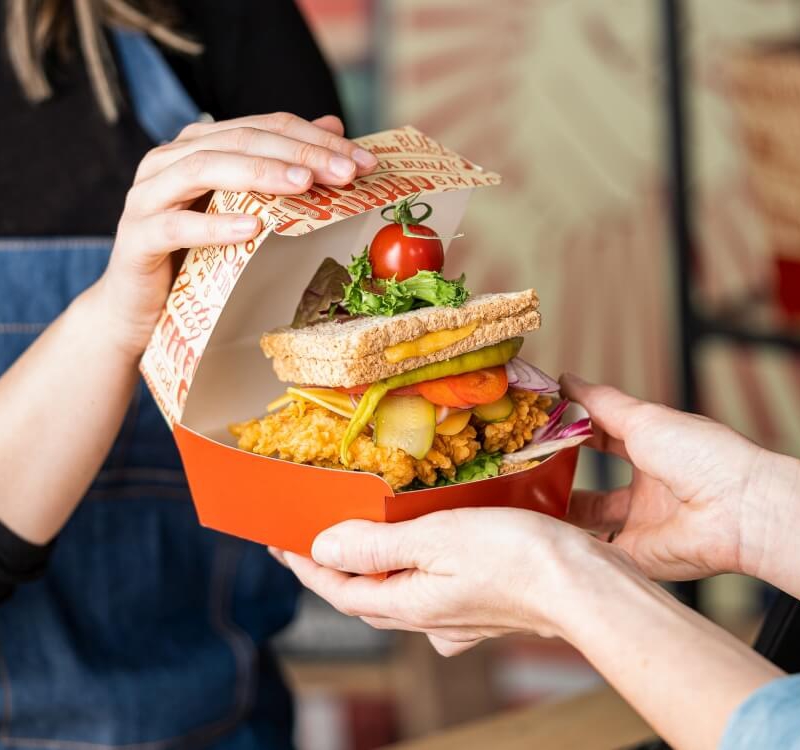 caja con hamburguesa en las manos