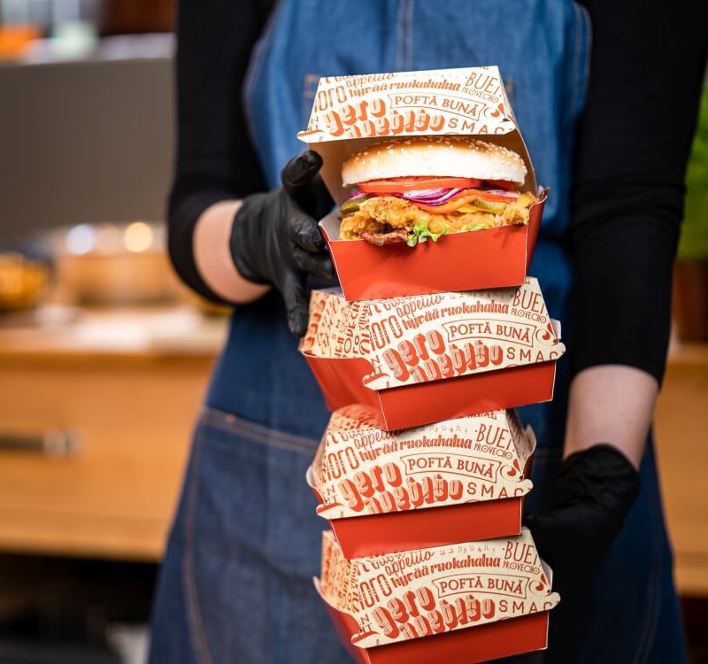 torre de cajas para hamburguesas en las manos